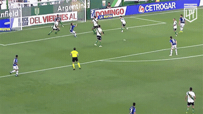 A Group Of Soccer Players Are Playing On A Field With An Advertisement For Banfield Behind Them GIF