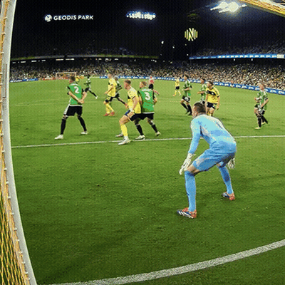 A Group Of Soccer Players Are Playing On A Field With Geodis Park In The Background GIF