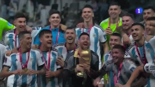 A Group Of Soccer Players Are Posing For A Picture While Holding A Trophy GIF