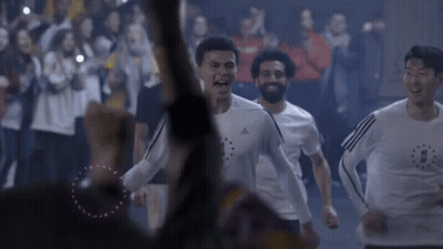 A Group Of Soccer Players Are Running In Front Of A Crowd Of People . GIF