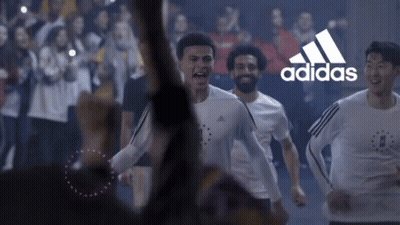A Group Of Soccer Players Are Running In Front Of A Crowd With The Adidas Logo In The Background GIF