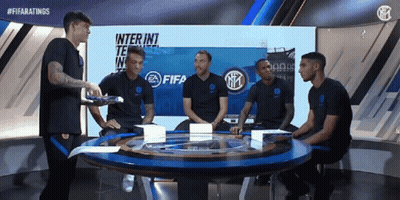 A Group Of Soccer Players Are Sitting Around A Table In Front Of A Fifa Logo GIF