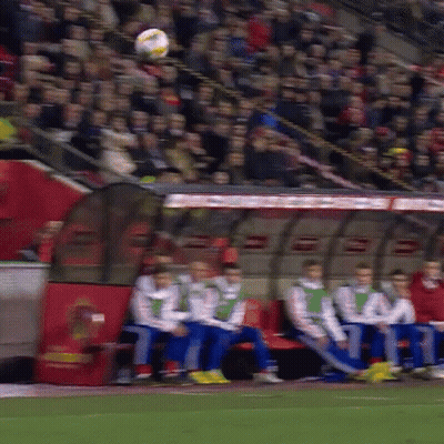 A Group Of Soccer Players Are Sitting In A Dugout Watching A Soccer Game GIF