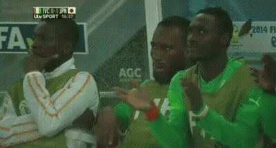 A Group Of Soccer Players Are Sitting In A Locker Room With A Sign That Says Agc On It GIF