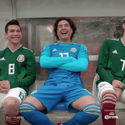 A Group Of Soccer Players Are Sitting On A Bench With Their Arms Crossed And Laughing . GIF
