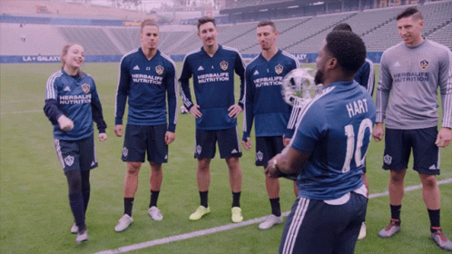 A Group Of Soccer Players Are Standing On A Field And One Of Them Is Wearing A Shirt That Says Hart GIF