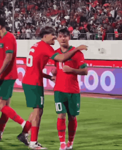 A Group Of Soccer Players Are Standing On A Field Hugging Each Other . GIF