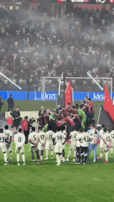 A Group Of Soccer Players Are Standing On A Field With A King Advertisement In The Background GIF