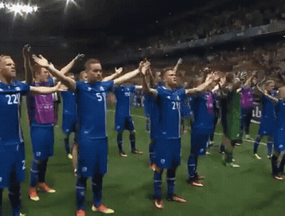 A Group Of Soccer Players Are Standing On A Field With Their Arms Outstretched And One Has The Number 21 On His Shirt GIF