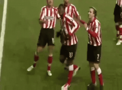 A Group Of Soccer Players Are Standing On Top Of A Soccer Field Celebrating A Goal . GIF