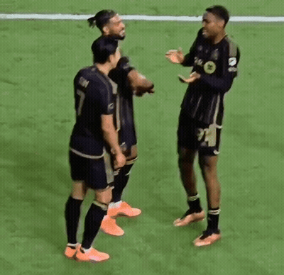 A Group Of Soccer Players Are Standing On Top Of A Soccer Field . GIF