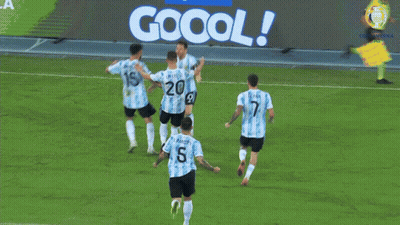 A Group Of Soccer Players Celebrate A Goal In Front Of A Jogo Oficial Sign GIF