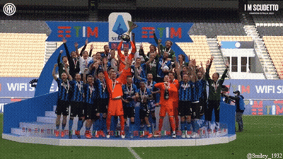 A Group Of Soccer Players Celebrate On A Podium With A Sign That Says Tim GIF