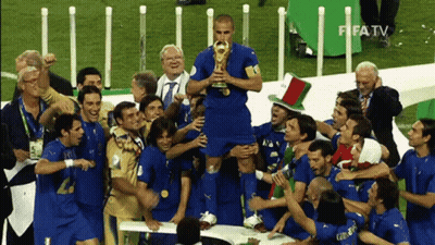 A Group Of Soccer Players Celebrate With A Man Holding A Trophy In Front Of Fifa Tv GIF