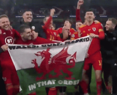 A Group Of Soccer Players Hold A Flag That Says In That Order GIF