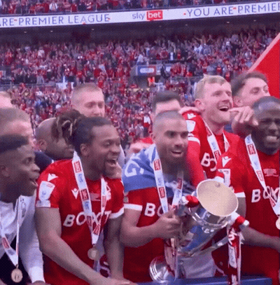 A Group Of Soccer Players Holding A Trophy In Front Of A Sky Bet Sign GIF
