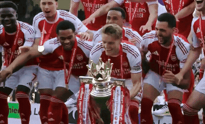 A Group Of Soccer Players Holding A Trophy With Emirates Written On Their Shirts GIF