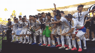 A Group Of Soccer Players Holding A Trophy With The Number 20 On The Back GIF