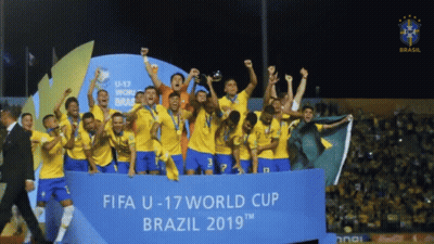 A Group Of Soccer Players Holding Up A Trophy In Front Of A Banner That Says Fifa U-17 World Cup Brazil 2019 GIF