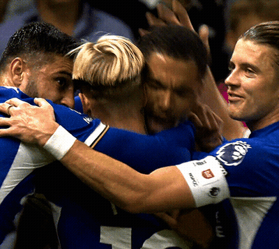 A Group Of Soccer Players Huddle Together With One Wearing A Wristband That Says ' Reebok ' On It GIF