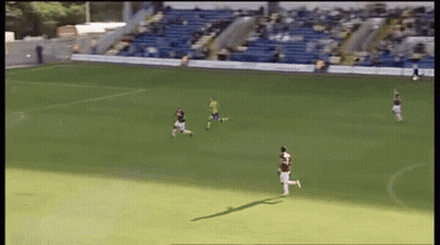 A Group Of Soccer Players On A Field With A Blue Bleacher In The Background GIF