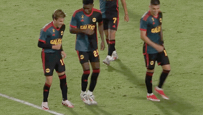 A Group Of Soccer Players Wearing Galaxy Jerseys Are Dancing On The Field GIF