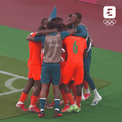 A Group Of Soccer Players Wearing Tokyo 2020 Jerseys Are Huddled Together GIF