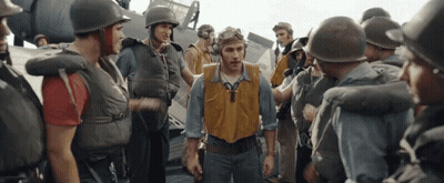 A Group Of Soldiers Are Gathered Around A Man Wearing A Yellow Vest With The Letter Y On It GIF