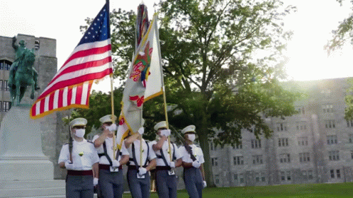 A Group Of Soldiers Are Holding Flags In Front Of A Building GIF