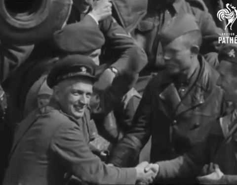 A Group Of Soldiers Are Shaking Hands In A Black And White Photo That Says Pathe GIF
