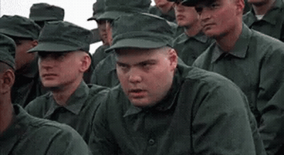 A Group Of Soldiers Are Sitting In A Row And Looking At The Camera . GIF