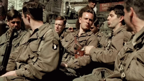 A Group Of Soldiers Are Sitting In Front Of A Sign That Says Source Of Lark GIF