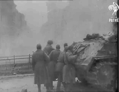 A Group Of Soldiers Are Standing Around A Destroyed Tank In A Black And White Photo Taken By Pathe GIF