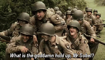 A Group Of Soldiers Are Standing In A Field And One Of Them Is Asking What Is The Goddamn Hold Up Mr Sobel . GIF