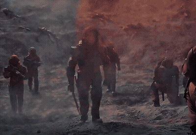A Group Of Soldiers Are Standing In Front Of A Fire GIF