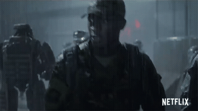 A Group Of Soldiers Are Walking In The Rain With A Netflix Logo In The Corner GIF