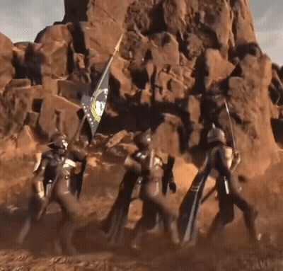 A Group Of Soldiers Carrying A Flag In Front Of A Large Rock Formation GIF