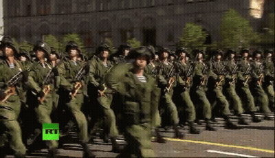 A Group Of Soldiers Marching In A Parade With A Green Rt Logo In The Corner GIF