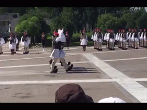 A Group Of Soldiers Marching In A Parade With A Man In A Costume That Looks Like A Horse GIF