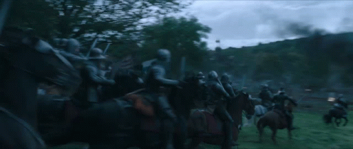 A Group Of Soldiers Riding Horses In A Field With Trees In The Background GIF