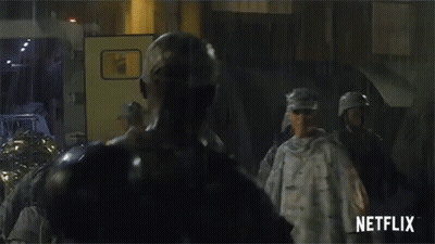 A Group Of Soldiers Standing In Front Of A Netflix Sign GIF