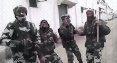 A Group Of Soldiers Standing Next To Each Other On A Street . GIF