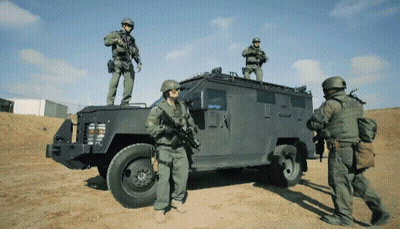 A Group Of Soldiers Standing On Top Of A Vehicle GIF