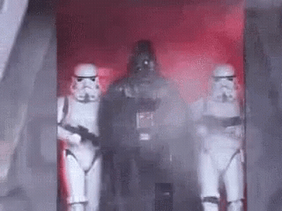 A Group Of Stormtroopers And Darth Vader Are Standing In A Room . GIF