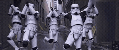 A Group Of Stormtroopers Are Jumping In The Air In A Street . GIF