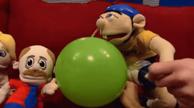 A Group Of Stuffed Animals Are Playing With A Green Balloon GIF