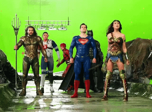A Group Of Superheroes Standing Next To Each Other In Front Of A Green Screen GIF