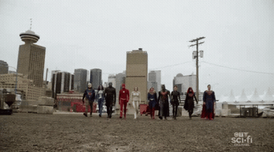 A Group Of Superheroes Walking In Front Of A City Skyline GIF