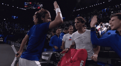 A Group Of Tennis Players High Five Each Other In Front Of A Scoreboard That Says Team Europe GIF