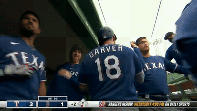 A Group Of Texas Rangers Players Standing In The Dugout GIF